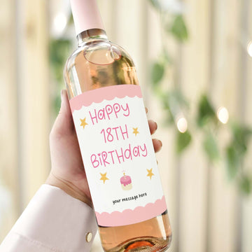 Custom wine label for an 18th birthday gift featuring pink text, stars, and a cake illustration on a wine bottle.