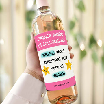 A wine bottle with a funny label reading "Chance made us colleagues, bitching about everything else made us friends," perfect for coworker gifts.