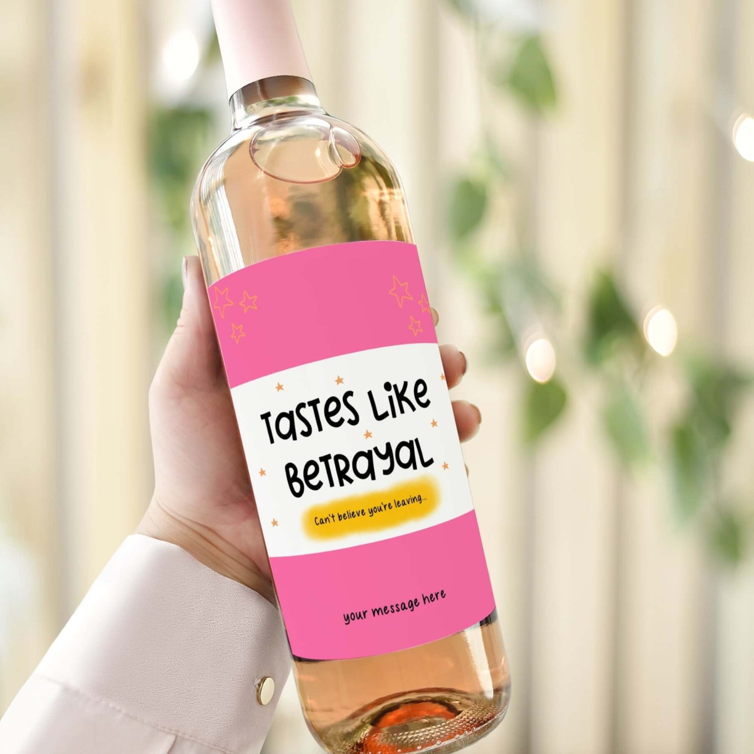 A wine bottle with a funny farewell label reading "Tastes Like Betrayal" in pink and yellow, ideal for farewell gifts or leaving parties.