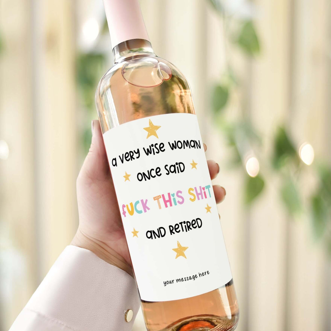 A wine bottle with a funny retirement label reading "A very wise woman once said f*** this sh** and retired," designed as a gift for her retirement.