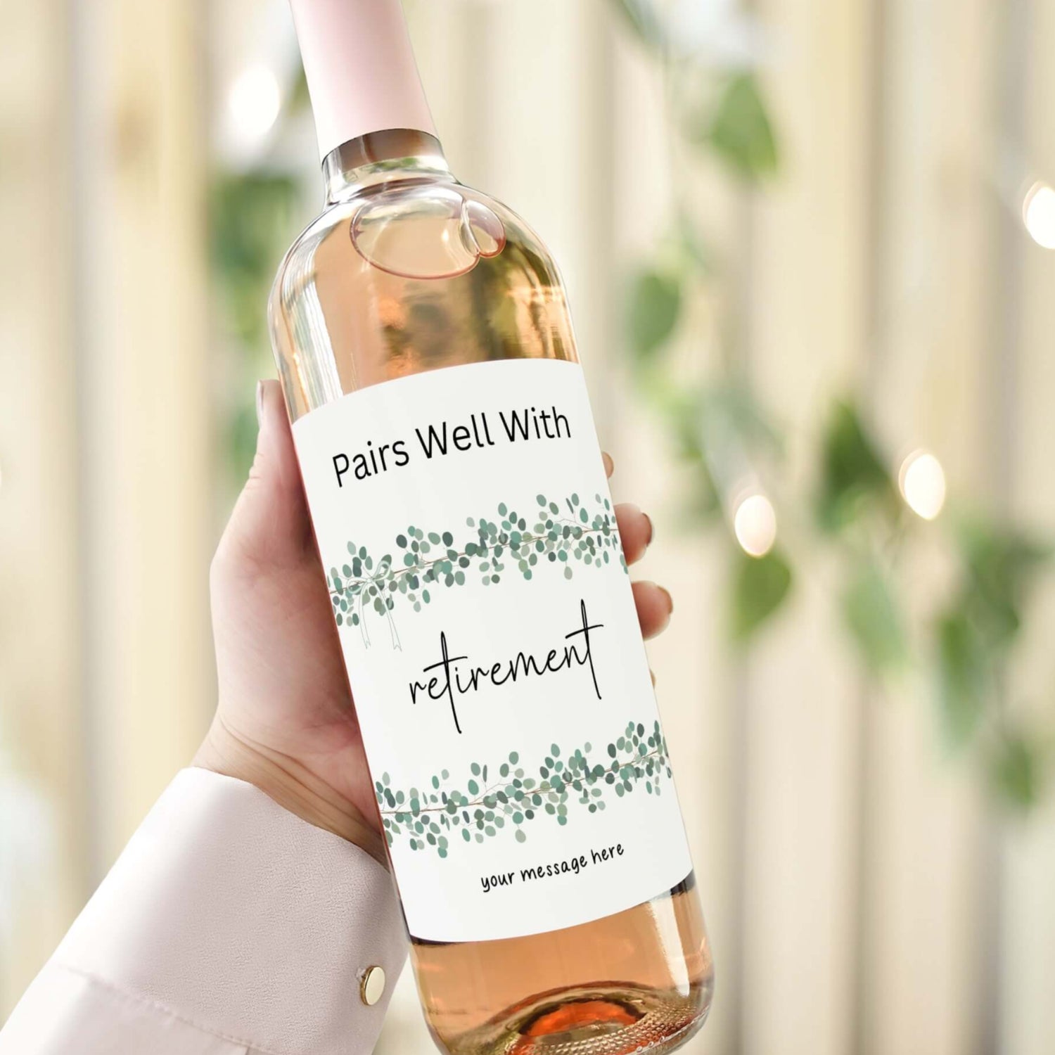 A wine bottle with a retirement label reading "Pairs Well With Retirement" featuring a eucalyptus design, perfect as a retirement gift.